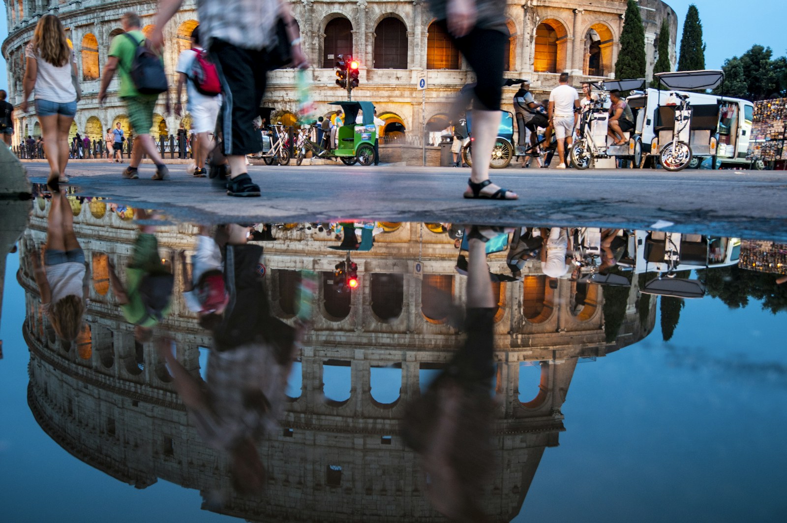 Riflesso del Colosseo in una pozza alla sera